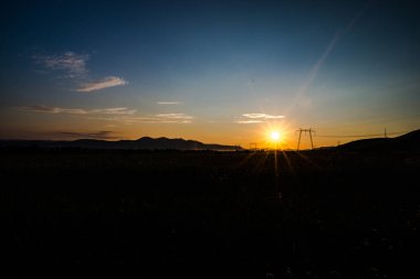 Güneş gizleme ile alan, karanlık gökyüzü günbatımı görünümü.