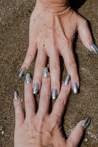 Vrouwelijke Handen Met Zilveren Nagellak Kust Achtergrond — Stockfoto