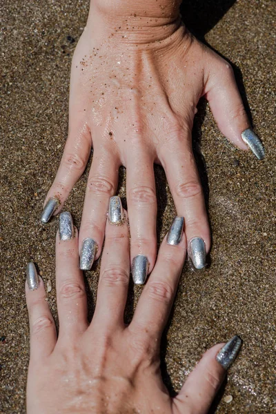 Vrouwelijke Handen Met Zilveren Nagellak Kust Achtergrond — Stockfoto