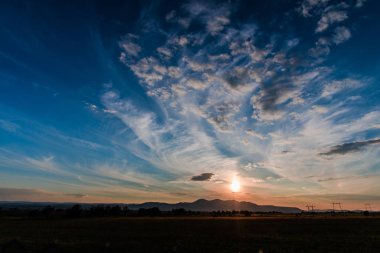 Alan alacakaranlıkta. Renkli gökyüzü ve kabarık bulutlar günbatımı arka plan.