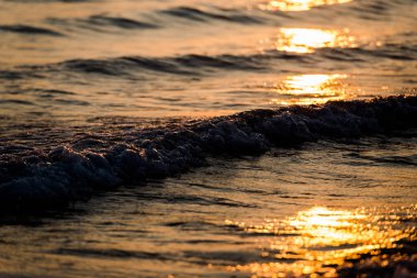 Arka planda dağlar gün batımında deniz kıyısı