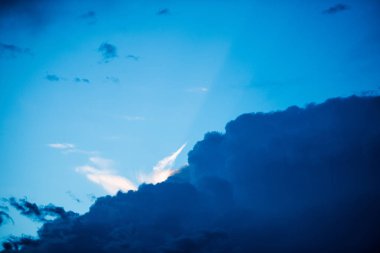 Karanlık ve mavi gökyüzü arka plan üzerinde beyaz bulutlar.