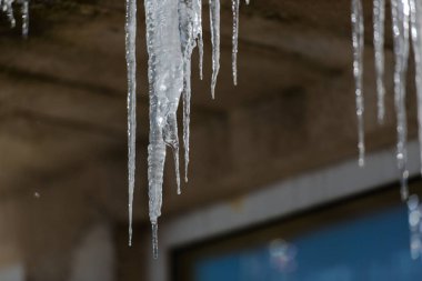 Ev çatıdan kışın asılı buz sarkıtları ayrıntı görünümü