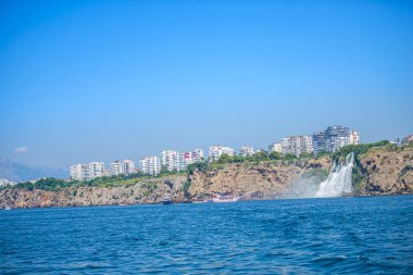 Arka planda kayalık kayalık ve Türk binaları ile deniz manzarası