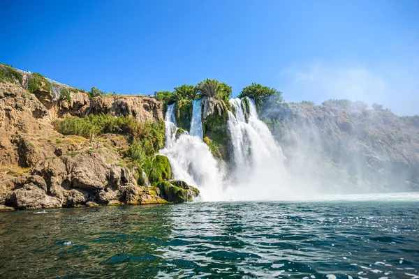 Rocky cliff with waterfall by black sea