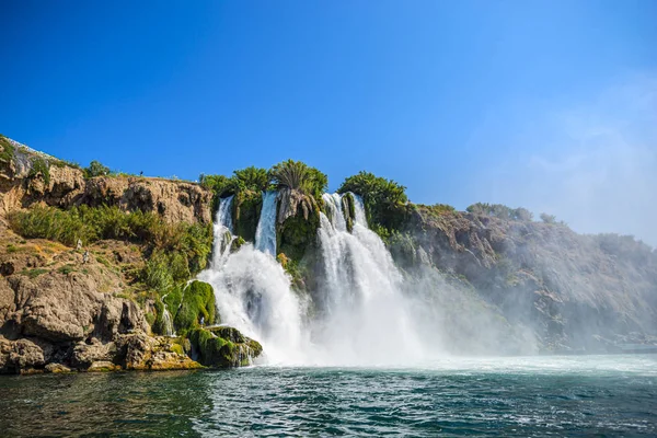 Rocky cliff with waterfall by black sea