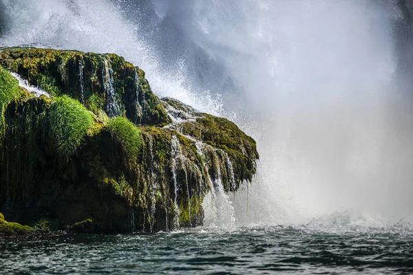 Rocky cliff with waterfall by black sea