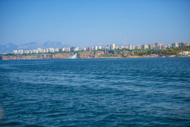 Arka planda kayalık kayalık ve Türk binaları ile deniz manzarası