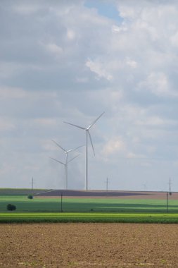 Yaz yeşili alanda modern rüzgar türbinleri.