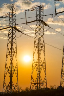 Yüksek gerilim elektrik direkleri ile akşam alanı