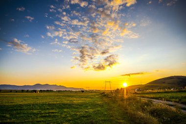 Elektrik direkleri ve bulutlu gökyüzü, doğal arka plan ile Alan