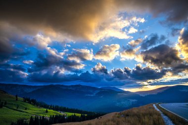 Bulutlu gökyüzü ile dağ yolunun dramatik manzarası