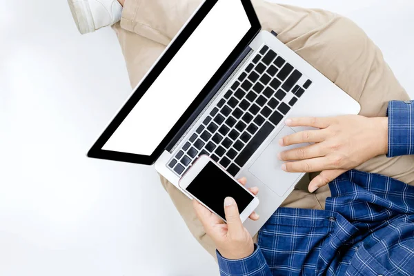 Jungunternehmer arbeitet am Laptop-Computer mit Smartphone, — Stockfoto