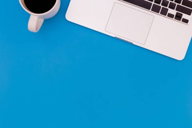 mavi masa üzerinde dizüstü bilgisayar ile modern işyeri düz yatıyordu Ofis masası masa, üst görünüm dizüstü arka plan ve siyah arka plan üzerinde kopya alanı, dizüstü bilgisayar ile mavi masa ofis, mavi arka plan üzerinde Yaz kavramı