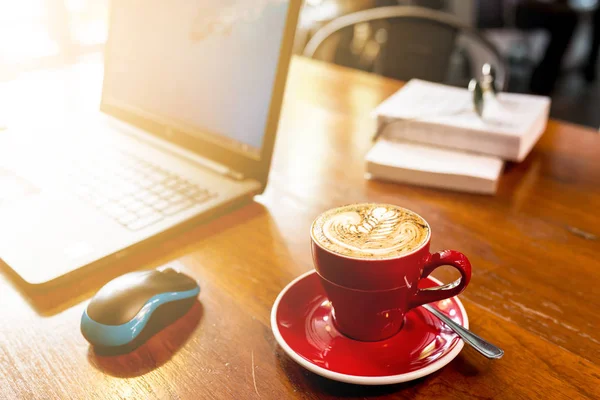 Кофе на деревянном столе с ноутбуком, горячий кофе с фоном ноутбука — стоковое фото