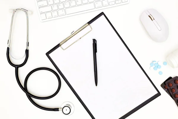 Stetoskop, Doktor masa masasının üst görünümü, beyaz arka planda boş kağıt, beyaz üzerinde görünüm Doktor iş araçları yukarıda,