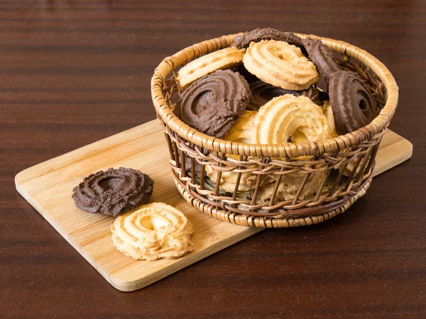 Vanilla and cocoa cookies in basket on the wooden table