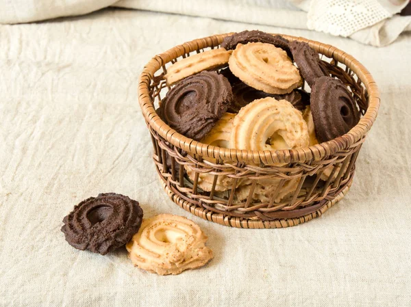 Vanilla and cocoa cookies in basket on the table with canvas tablecloth