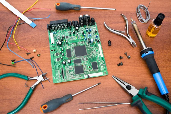 Electronic system board with microcircuits and electronic components. Necessary tools for repair. — Stock Photo, Image