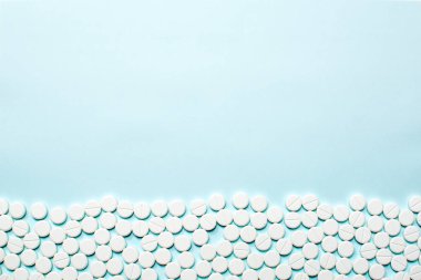 Satır birçok hapları veya tablet ışık mavi masada. Tıbbi kavramı, kopya alanı.