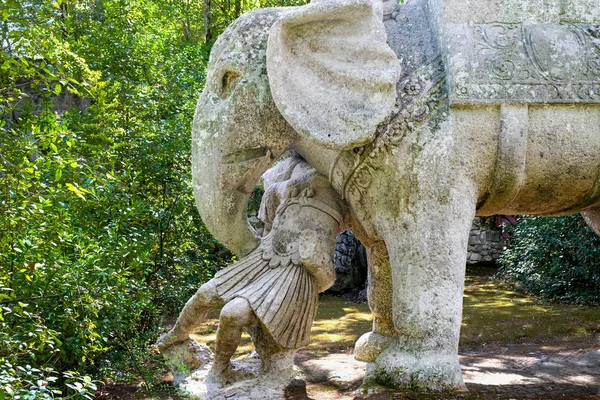 Ancient renaissance sculpture War Elephant and Roman Legionnaire at the famous Parco dei Mostri, also called Sacro Bosco or Giardini di Bomarzo. Monsters park. Lazio, Italy