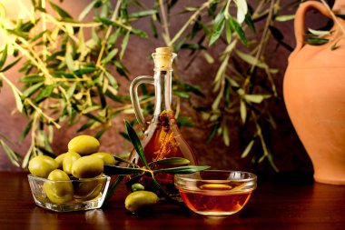 Trdition Girit spieces rosemary ile zeytinyağı ve zeytin, kil sürahi ile biber aromalı ve zeytin ahşap arka plan üzerinde yapraklar.
