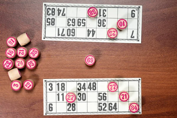 Masa oyunu Loto veya bingo. Ahşap loto numaraları ve kahverengi masa kartı ile iki oyuncu oyun sırasında varil. Vintage oyunu. — Stok fotoğraf