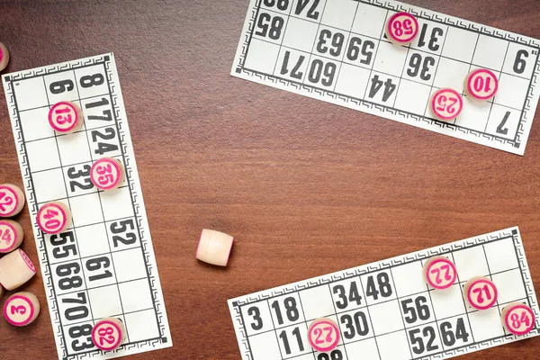Masa oyunu Loto veya bingo. Ahşap loto numaraları ve kart kahverengi masa üzerinde üç kişilik bir oyun sırasında varil. Vintage oyunu. — Stok fotoğraf