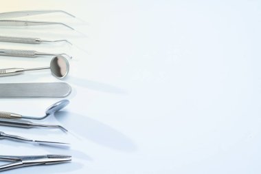 Diş hekimi araçlar mavi yüzeyi: iki diş ayna, corncang, küret, diş sonda, brüt-mayer kelepçe ve kaşifler. Dişlerle ilgili sağlık bilgisi ve kopya alanı ile sağlık kavramı.