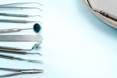 Diş hekimi araçlar mavi yüzeyi: iki diş ayna, corncang, küret, diş sonda, brüt-mayer kelepçe ve dört kaşifler. Dişlerle ilgili sağlık bilgisi ve kopya alanı ile sağlık kavramı.