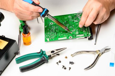 Elektronik teknisyeni elektronik cihazın non-çalışma öğesi bir havya ile yerini alır. Bir elektronik mühendisi, onarım elektronik cihazlar kavramı eller.