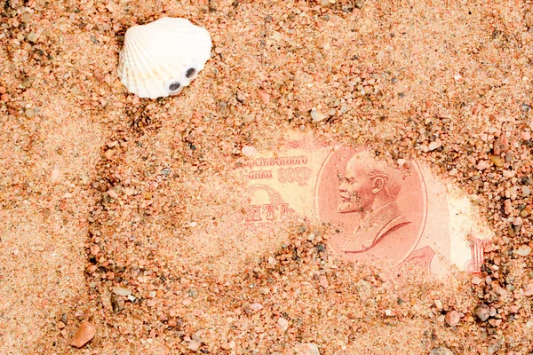 Морські раковини на Гуглі очі, лежать на піску і подивіться на старі радянські банкнота. Десять рублів СРСР з Закри портрет Леніна. — стокове фото
