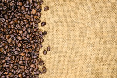 Vintage kahve arka plan. Jüt çuval bezi üzerinde kavrulmuş kahve çekirdekleri.
