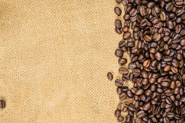 Vintage kahve arka plan. Eski jüt çuval bezi üzerinde kavrulmuş kahve çekirdekleri.