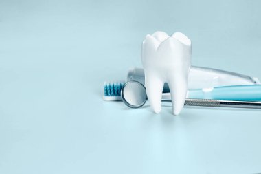 White big healthy tooth, toothbrush and toothpaste for dental care, on light blue dental background. clipart