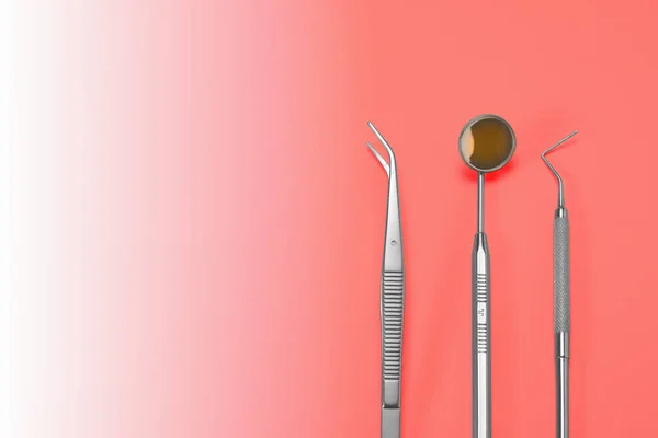 Dentist tools: mirror, dental probe and tweezers on living coral gradient background. — Stock Photo, Image