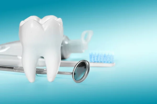 White big healthy tooth and different tools for dental care, on gradient dental background.