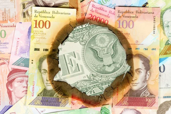 Venezuela hiperenflasyon kavramı. Farklı bolivar değeri nekadar yanmış Venezuela banknotları, yanmamış bir dolarlık banknotu ters tarafı görebileceğiniz delikten. Yakın çekim — Stok fotoğraf