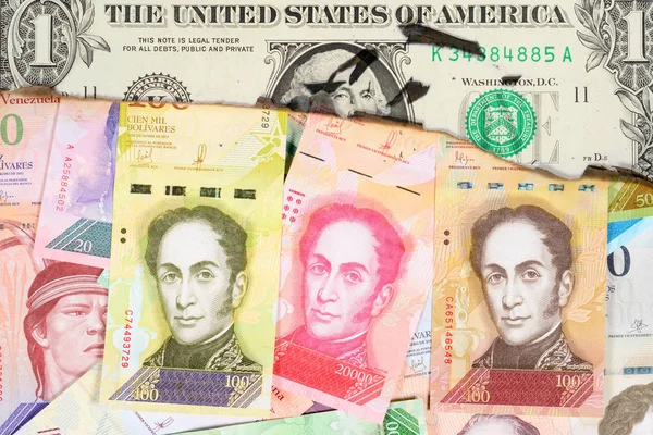 Conceito de hiperinflação Venezuela. Dinheiro venezuelano queimado com a imagem de estadistas, através de um buraco no qual você pode ver uma nota de um dólar não queimada. Fechar . — Fotografia de Stock