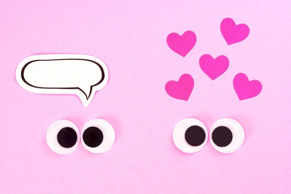 Occhi da googly. Strana coppia di amanti strabici su sfondo rosa con alcuni piccoli cuori e copiare lo spazio per i pensieri. Chiudi gli occhi giocattolo . — Foto Stock