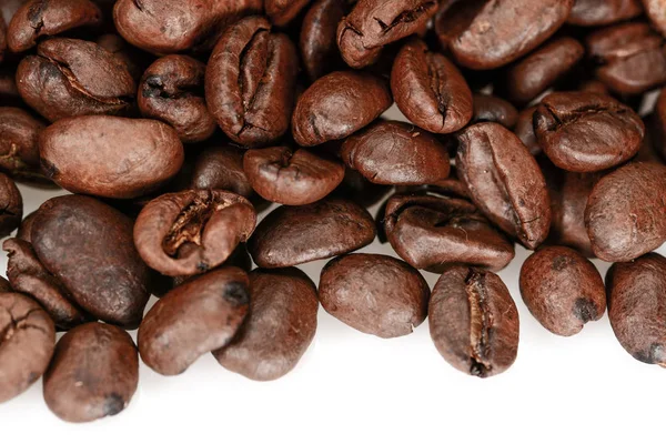 Kahverengi sert kavrulmuş kahve çekirdekleri, makro yakın, beyaz bir arka plan üzerinde izole — Stok fotoğraf