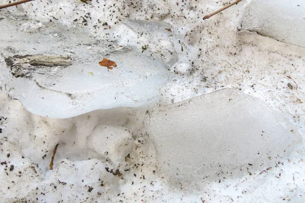 Блоки льоду в брудному джерелі розтанув сніг. Білий фон . — стокове фото