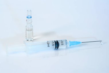 Tıbbi solüsyon ile açık mavi bir arka plan üzerinde Şırınga. 2 ml şırınga yakın, ilaç bir ampul ile