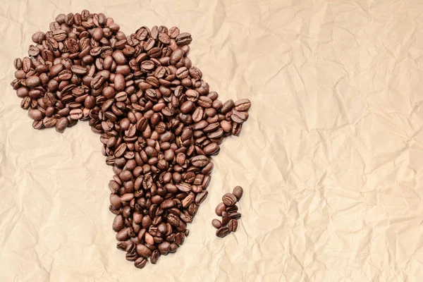 Cała Kawa ziarnistą. Kontur kontynentu afrykańskiego jest wykonany z ziaren kawy na Starym rozdrobnione papieru — Zdjęcie stockowe
