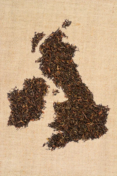 Loose black tea. The contour of the Great Britain is made from England breakfast tea on homespun linen canvas background, United Kingdom map.