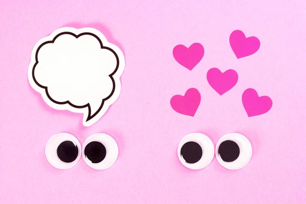 Occhi googly di strana coppia di amanti su sfondo rosa con alcuni piccoli cuori e copiare lo spazio per i pensieri. Chiudi gli occhi giocattolo . — Foto Stock
