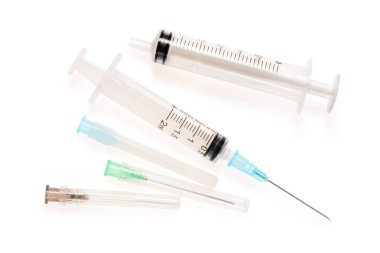 İki şırınga ve üç iğne. 2 ve 6 ml tek kullanımlık şırınga yakın, gölge ile beyaz arka plan üzerinde izole