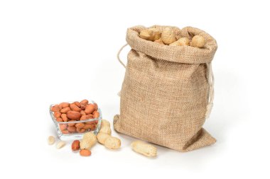 Fıstık. Bazı soyulmuş çekirdekleri ile fıstık ve cam kase dolu Jüt çuval, gölgeler ile beyaz arka plan üzerinde izole.