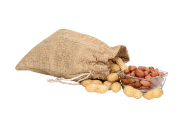 Fıstık. Fıstık dolu çuval bezi çuvalı ve soyulmuş çekirdekli cam kase, gölgesiz beyaz arka planda izole edilmiş..