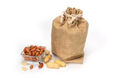 Fıstık. Bazı soyulmuş çekirdekleri ile fıstık ve cam kase dolu Jüt çuval, gölgeler ile beyaz arka plan üzerinde izole.
